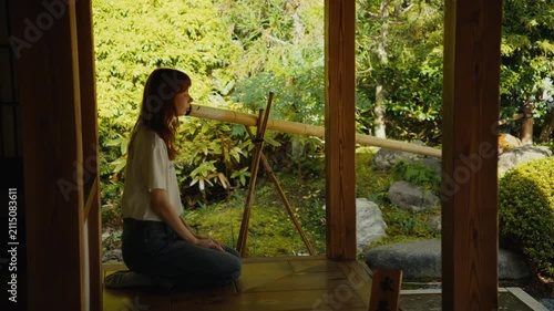 Woman meditating kneeling in a traditional japanese garden