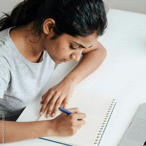 Young indian woman writing ...