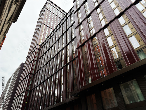 Modern high rise office building facade in Manchester, UK with reflective glass and vertical red panels