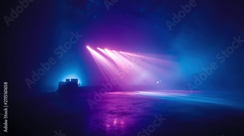Stage lights illuminate a dark, smoky room with vibrant pink and blue hues