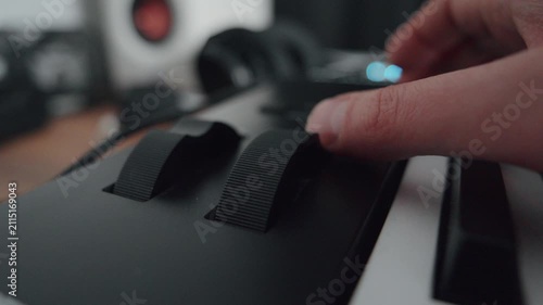 A hand is pressing keys on an electronic keyboard in a music studio