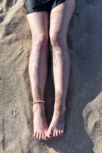 Beautiful women's legs on the beach