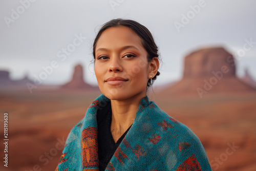 Portrait of beautiful indigenous native american woman wrapped in traditional blanket in Monument Valley