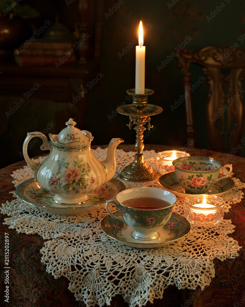 Fototapeta premium Vintage Afternoon Tea Still Life: Cozy Teapot and Teacup Set with Romantic Candlelight on Elegant Table Setting