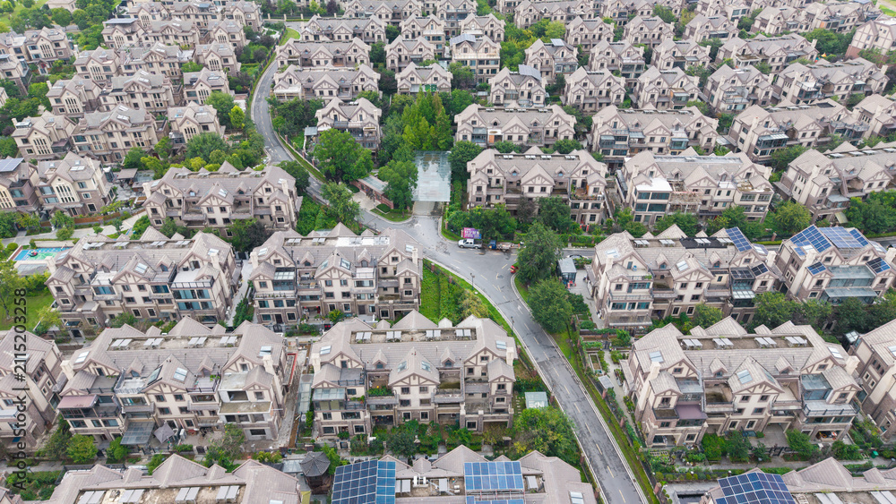 Obraz premium Aerial wide view of dense villa residential community beside lake with lush green trees