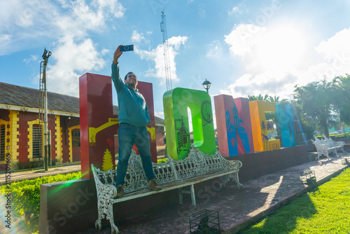 Man taking selfie at honey puebla letters landmark