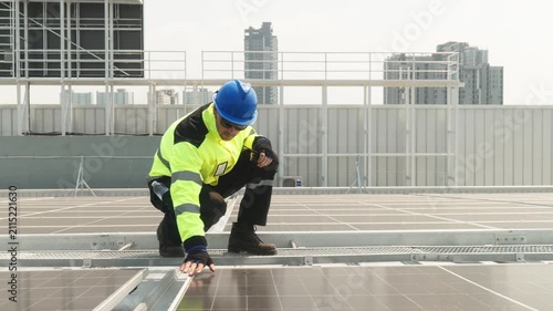Close-up of solar technician measuring spacing between photovoltaic panels during rooftop installation and alignment of a solar energy system.