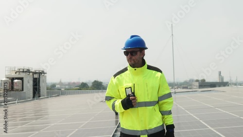 Close-up of solar technician measuring spacing between photovoltaic panels during rooftop installation and alignment of a solar energy system.