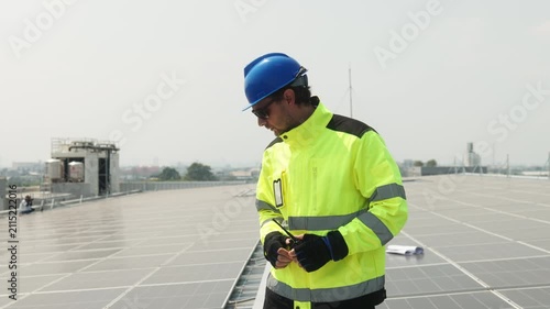 Close-up of solar technician measuring spacing between photovoltaic panels during rooftop installation and alignment of a solar energy system.
