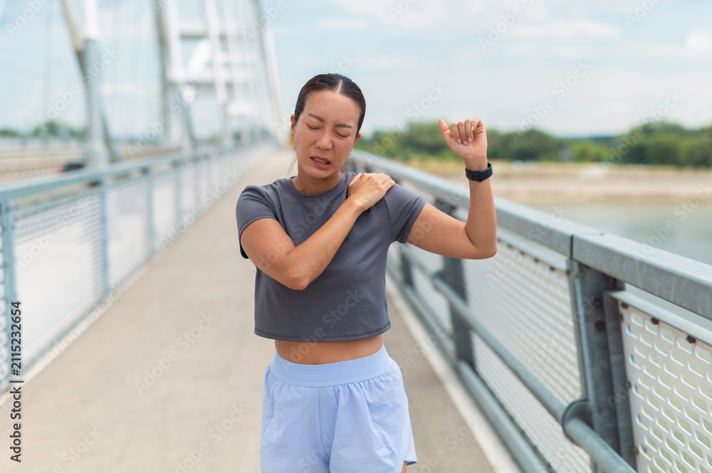 Fototapeta premium Female runner experiencing shoulder pain after exercise