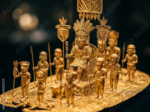 Golden pre columbian raft artifact figure on dark background
