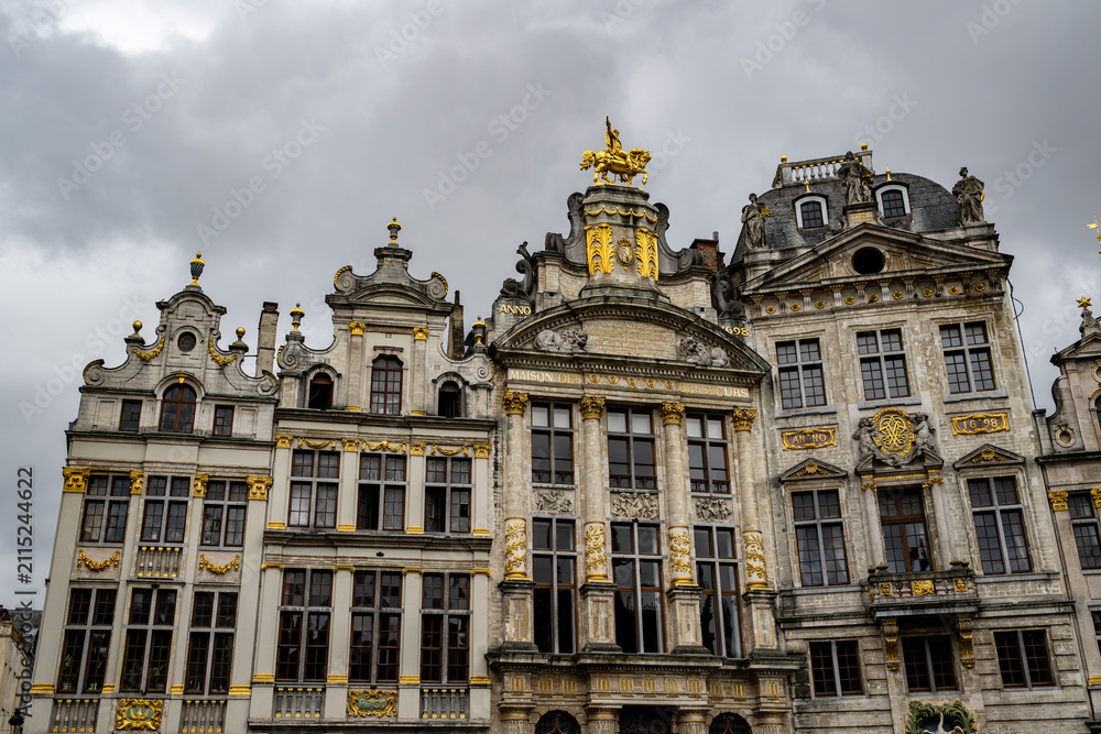 Fototapeta premium Historic guild houses on Grand Place under dramatic storm clouds at Grand Place, Brussels, Belgium