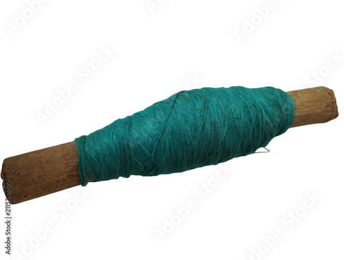 Green yarn thread wound on a wooden stick