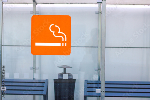 Modern glass smoking shelter with designated smoking area sign