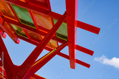 Modern red metallic structures with colorful glass against the blue sky