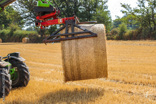 Tractor collecting cut grass in rural field