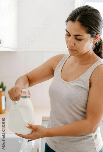 Young woman pouring liquid ...