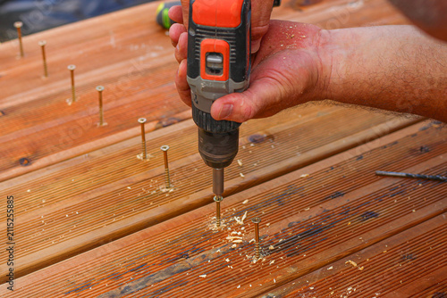 Man nailing the wooden boards to fix the terrase