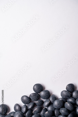 Black Lentils Forming a Bottom Border on White Background with Copy Space