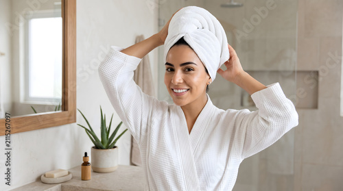 Woman in bathrobe with towel on head smiling