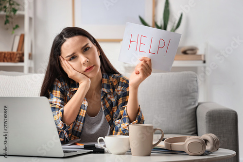 Overwhelmed young woman hol...