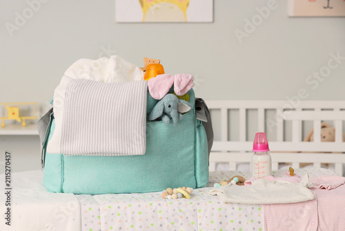 Baby bag with accessories on changing table in room