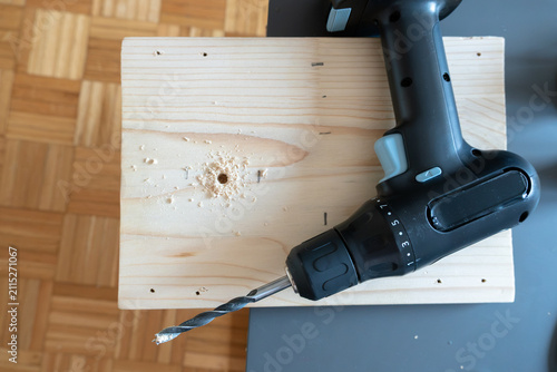 Obraz na plátne Cordless drill and fresh mounting hole on board for light installation
