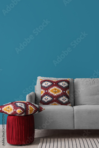 Stylish grey sofa with pill...