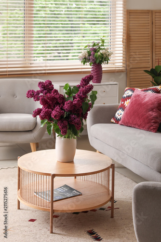 Lilac flowers in vase on co...