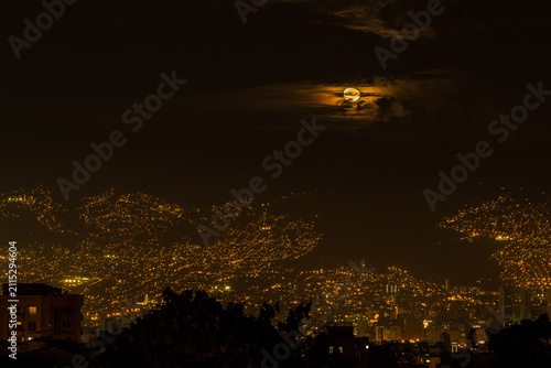 Full Moon Glowing Through Clouds Above Medellín Skyline