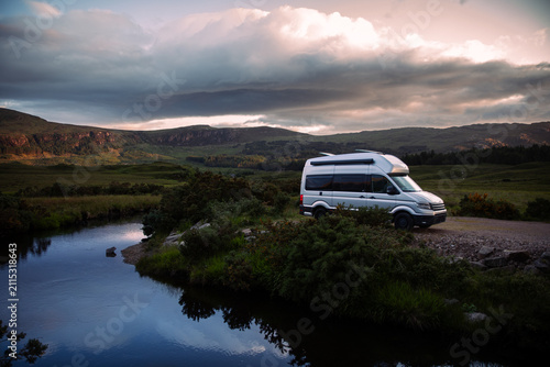 Campervan beside a Highland stream in remote Scotland
