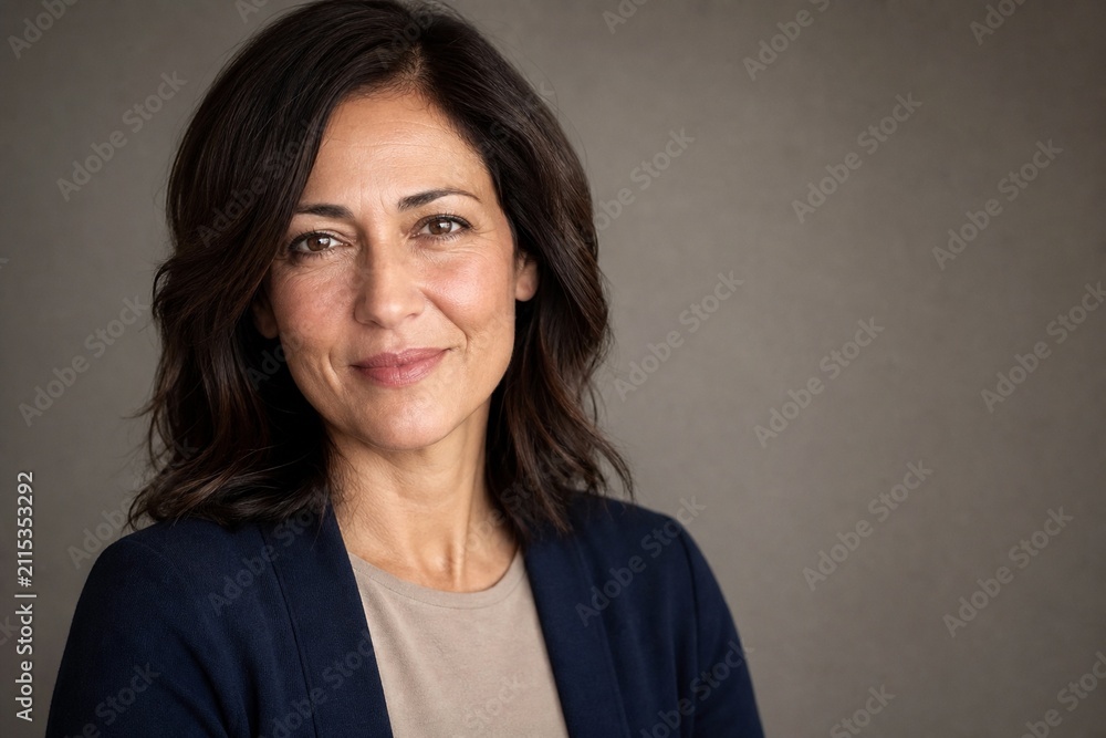 Fototapeta premium Authentic Confident Fictional Middle Aged Woman Portrait on Warm Gray Background With Clean Copy Space