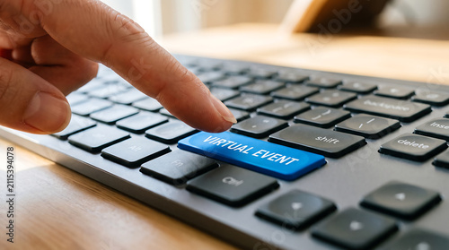 Hand pressing blue virtual event button on computer keyboard for online graduation ceremony and academic webinar session