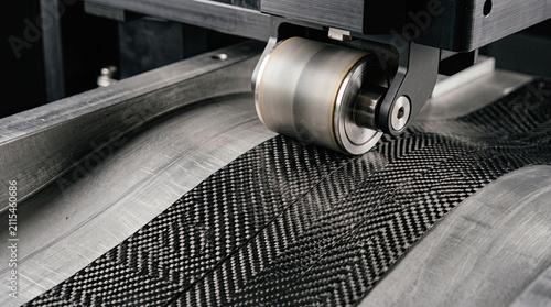 Machine roller applying carbon fiber fabric to curved surface with industry