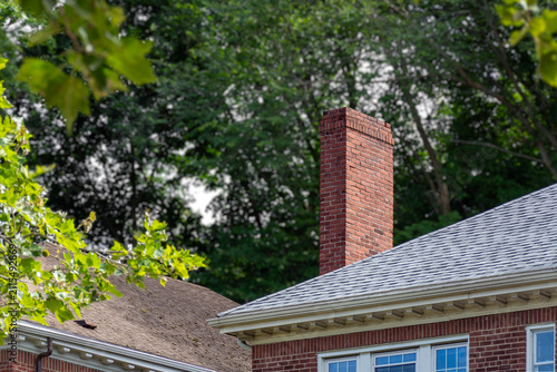 Red brick chimney and shingle roof with white dentil molding in Boston