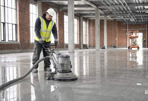 Worker cleans concrete floor with machine