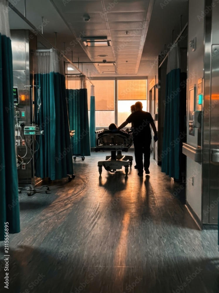 Fototapeta premium Hospital Hallway Scene With Patient Moving Towards Sunset Window View