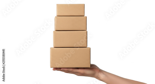 A hand holding a stack of four brown cardboard boxes isolated on transparent background