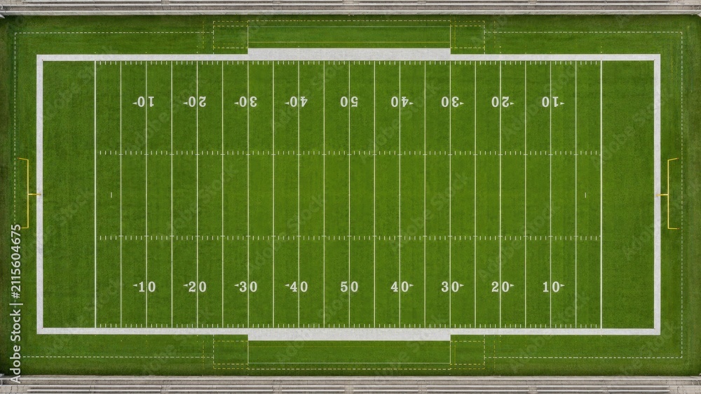 Fototapeta premium Aerial top-down view of an American football field with marked yard lines, goalposts, green turf, white markings and surrounding bleacher seating