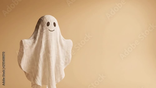 Halloween ghost costume sheet cute minimal beige background playful mood smile floating copyspace minimal beige ghost sheet
