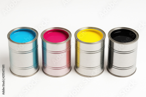 Four paint can with cyan, magenta, yellow, black color standing on white background, representing print color concept and ink mixing