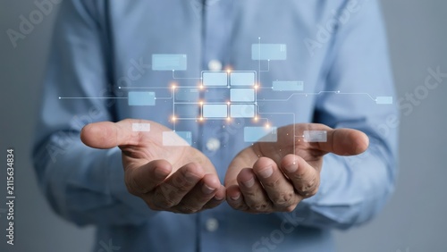 Businessman holding a digital flowchart network interface in his open hands