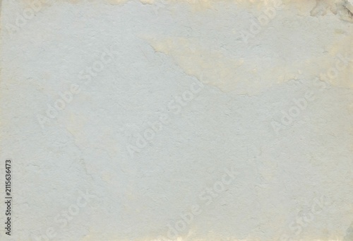 Close-up of a textured, light-colored surface with slightly uneven tones, resembling natural stone or rough paper