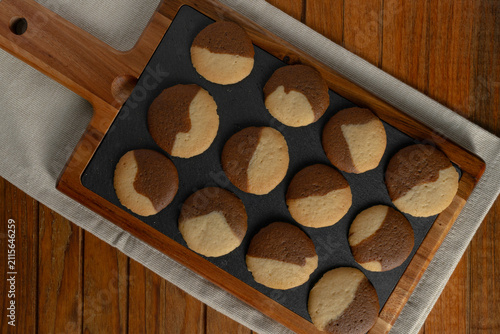 Home kitchen scene homemade coffee flavor and vanilla Cookies on kitchen board, cooling ready to eat on a rustic wooden table.