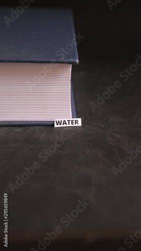 Water Paper Label Beside Book Representing Nature and Life Essential