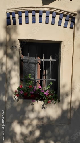 Charming European Building Facade with Flower Boxes and Sunlight Shadows