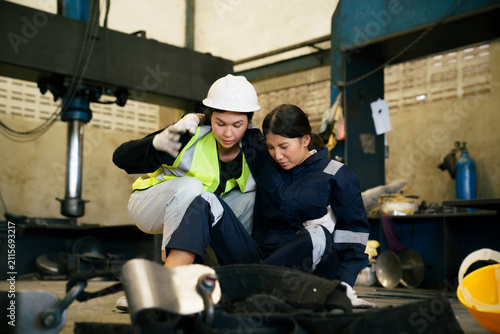 Factory worker helping injured colleague after accident on shop floor