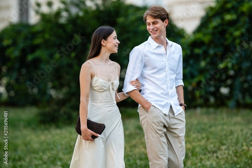 Foto Young couple walking outdoors, smiling and happily interacting