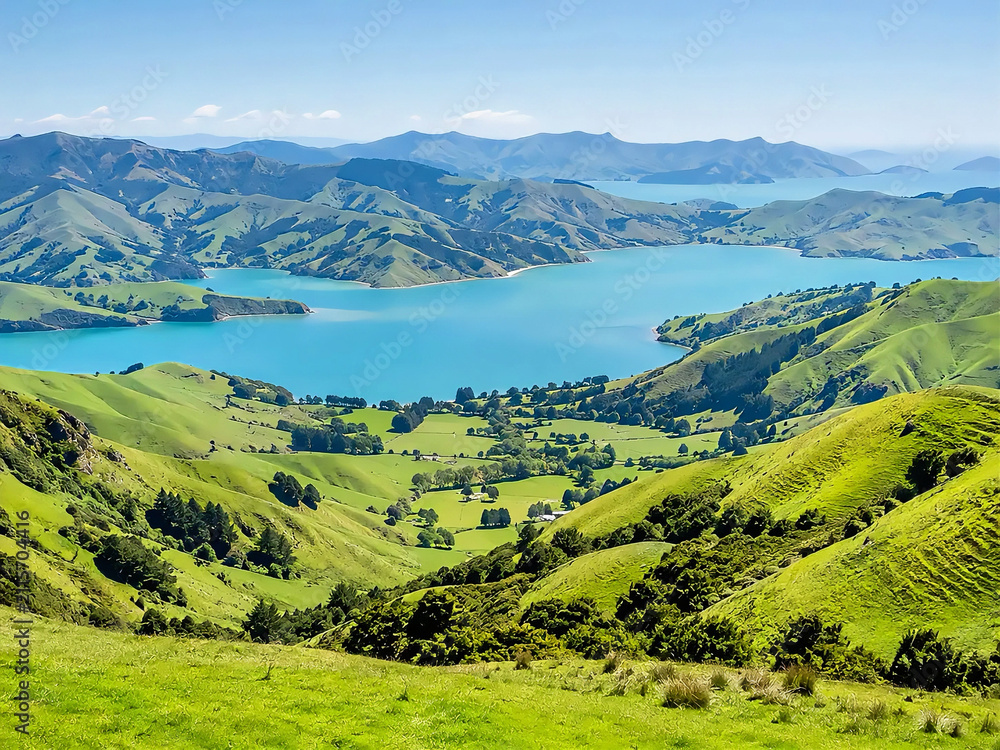 Fototapeta premium Rolling Green Hills Surrounding Turquoise Harbor Inlet, Banks Peninsula New Zealand