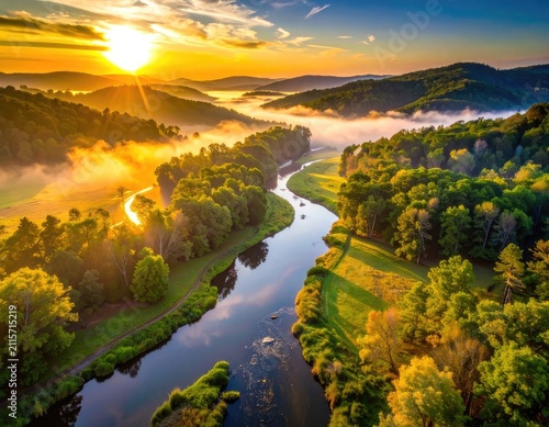 Golden sunrise over a misty river valley with lush green forests.